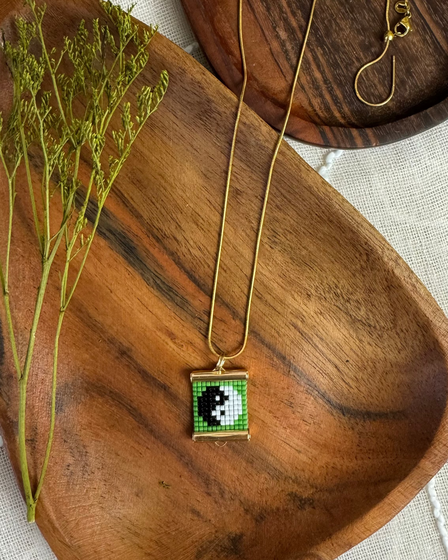 Necklace with a square pendant on a wooden surface