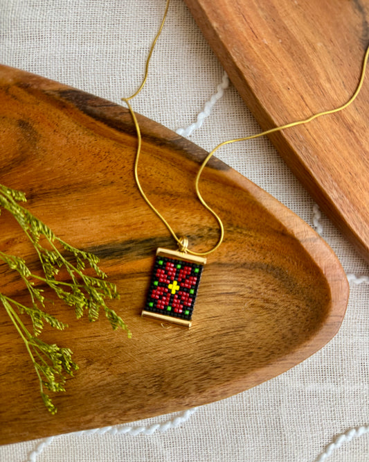 Necklace with a small poinsettia pendant on a wooden surface
