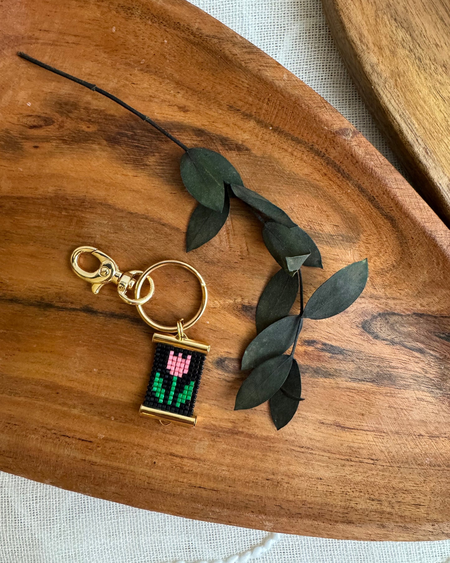Keychain with Tulip motif on a wooden surface with leaves