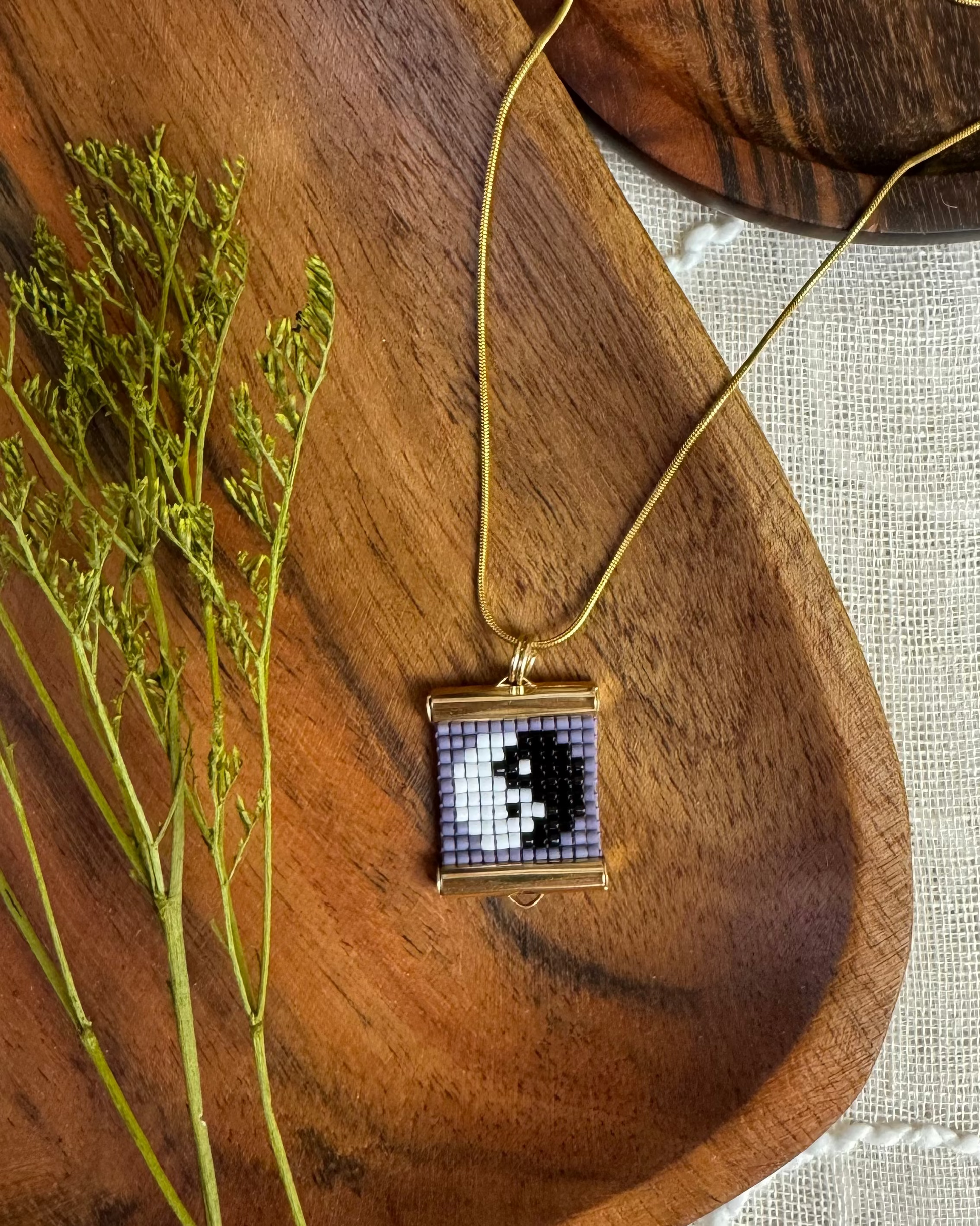 Necklace with a beaded pendant on a wooden surface
