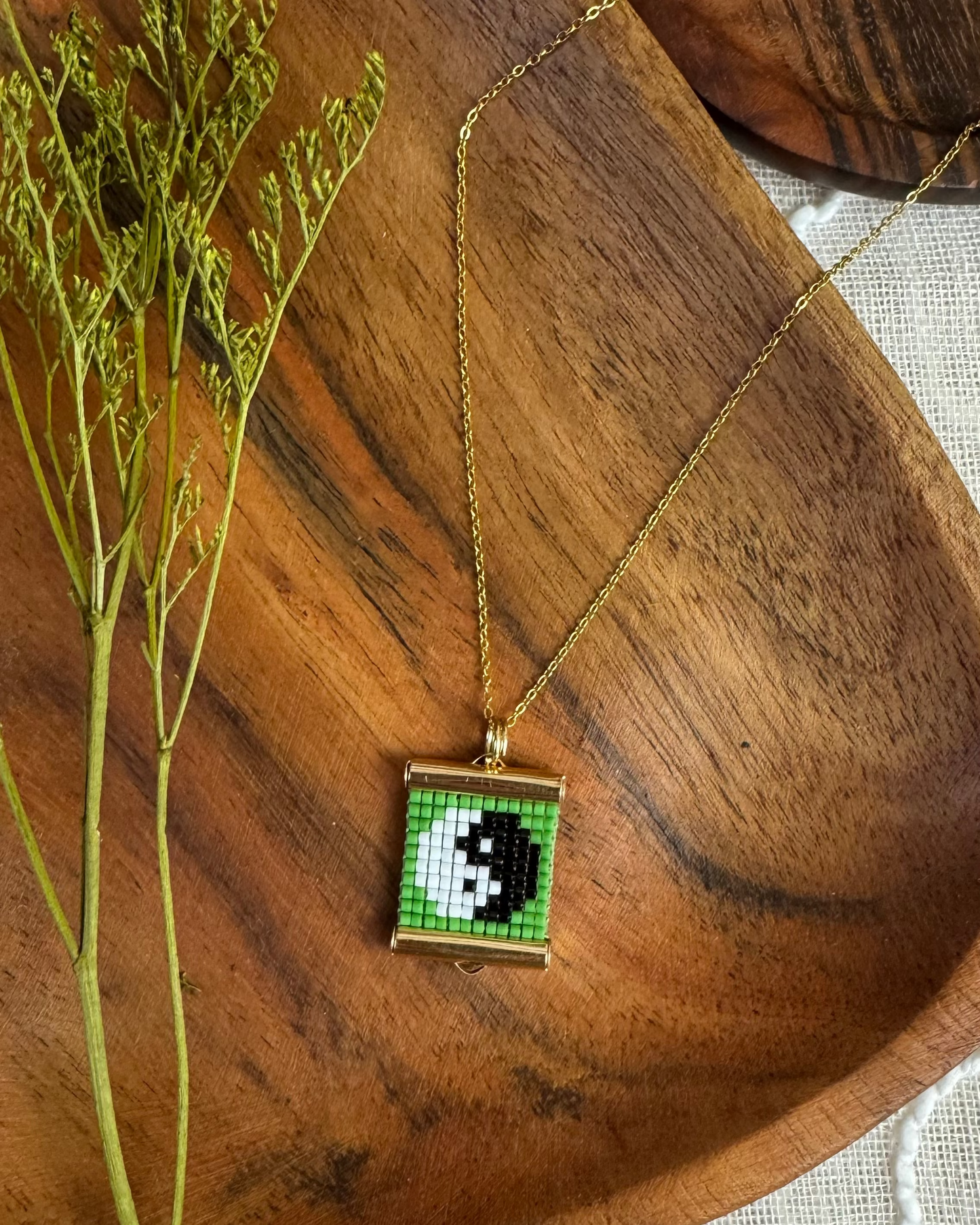 Necklace with a beaded pendant on a wooden surface