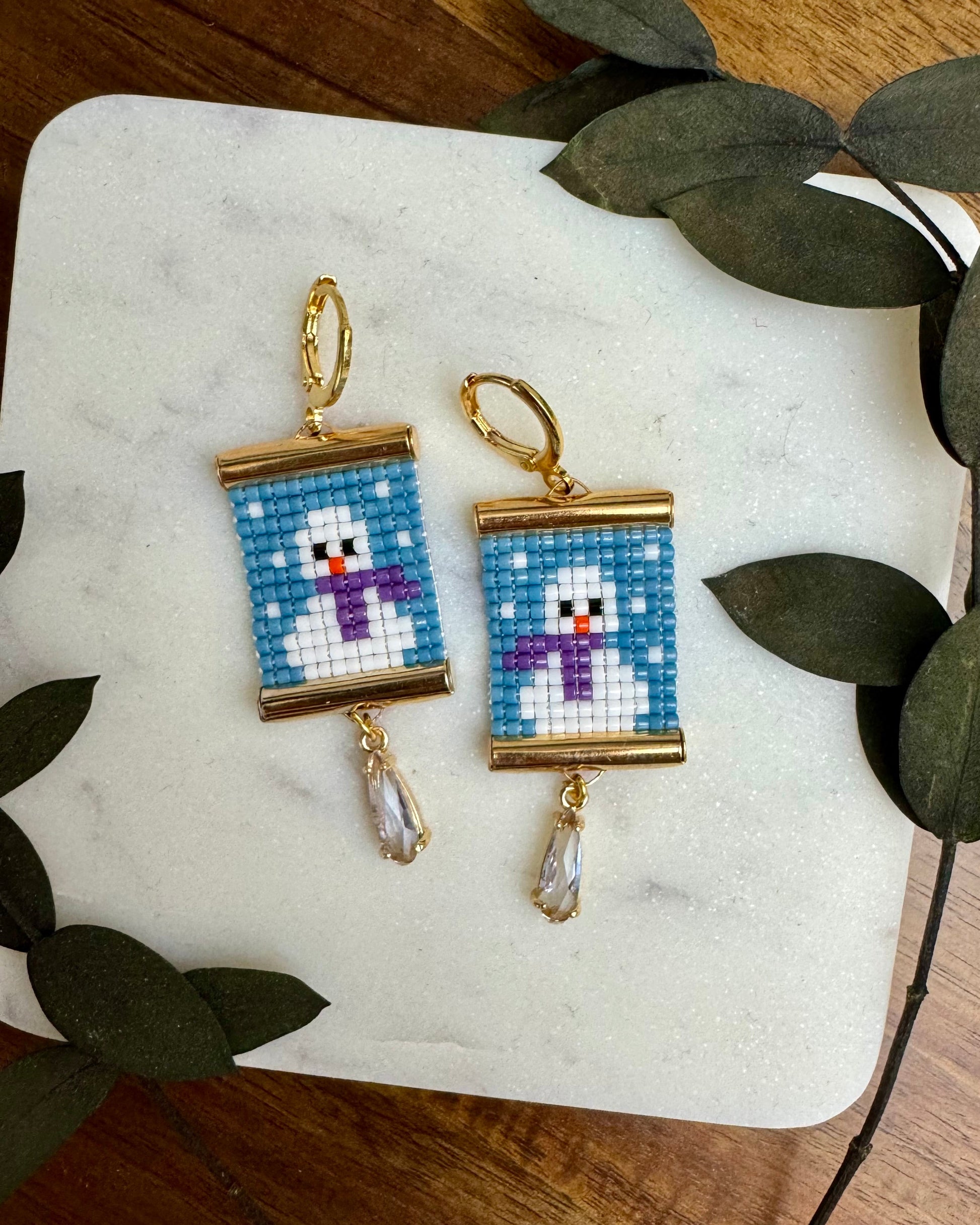Beaded earrings depicting snowmen.